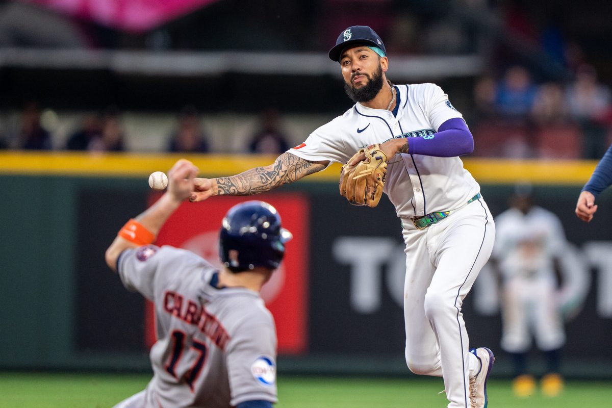 Jul 19, 2025; Seattle, Washington, USA;  Seattle Mariners shortstop J.P. Crawford (3) turns a double play after forcing out Houston Astros right fielder Cam Smith (11) at second base during the fifth inning at T-Mobile Park. Mandatory Credit: Stephen Brashear-Imagn Images