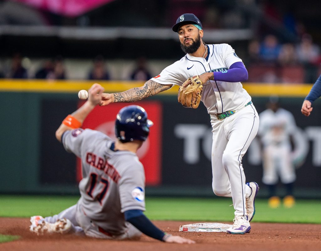 Jul 19, 2025; Seattle, Washington, USA; Seattle Mariners shortstop J.P. Crawford (3) turns a double play after forcing out Houston Astros right fielder Cam Smith (11) at second base during the fifth inning at T-Mobile Park. Mandatory Credit: Stephen Brashear-Imagn Images