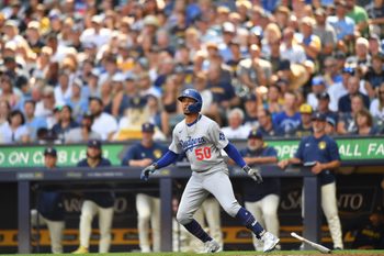 Jul 9, 2025; Milwaukee, Wisconsin, USA; Los Angeles Dodgers shortstop Mookie Betts (50) watches his sacrifice fly RBI during the seventh inning against the Milwaukee Brewers at American Family Field. Mandatory Credit: Patrick Gorski-Imagn Images