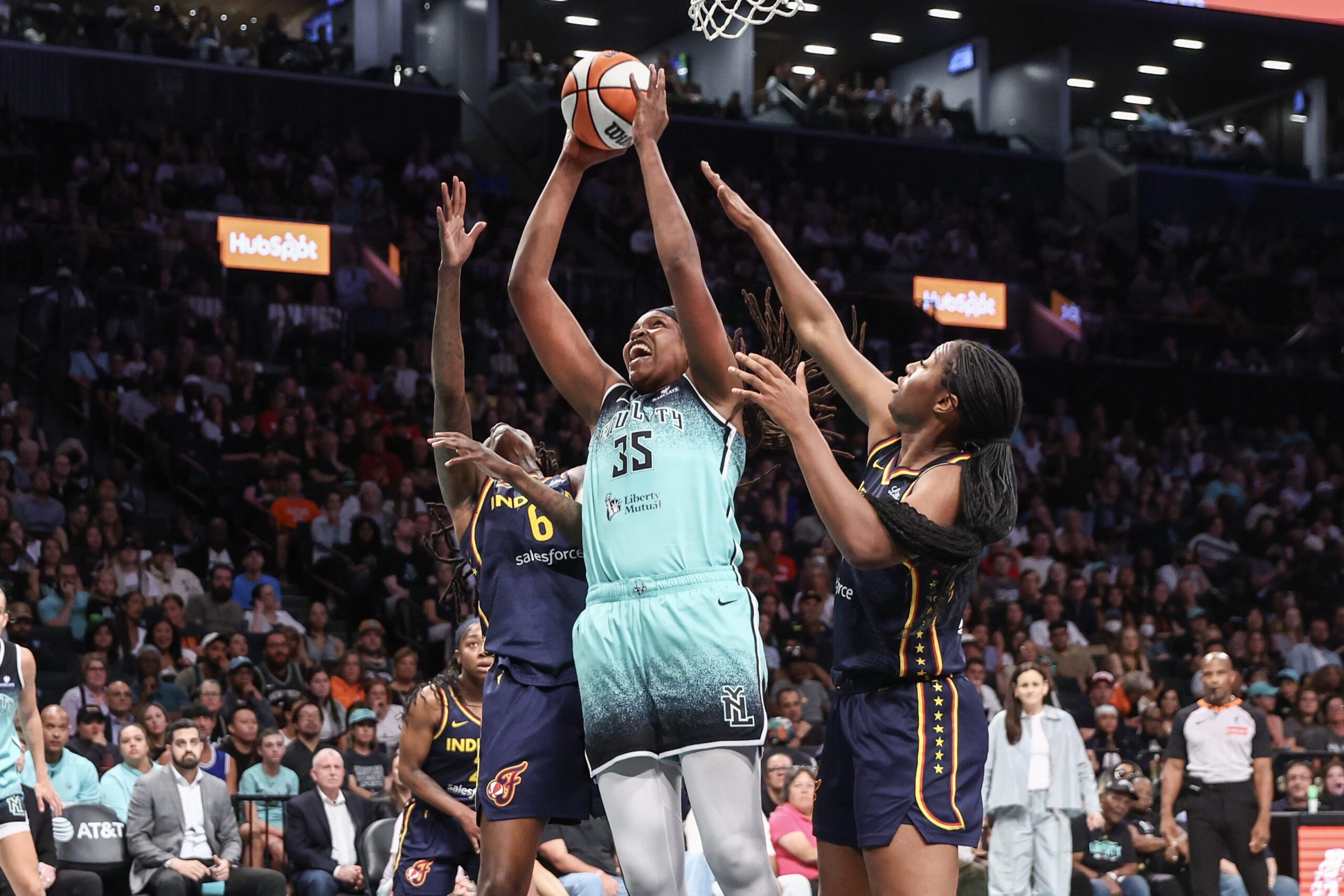 Jul 22, 2025; Brooklyn, New York, USA; New York Liberty center Jonquel Jones (35) jumps in front of Indiana Fever forwards Natasha Howard (6) and Aliyah Boston (7) to grab a rebound in the first quarter at Barclays Center. Mandatory Credit: Wendell Cruz-Imagn Images