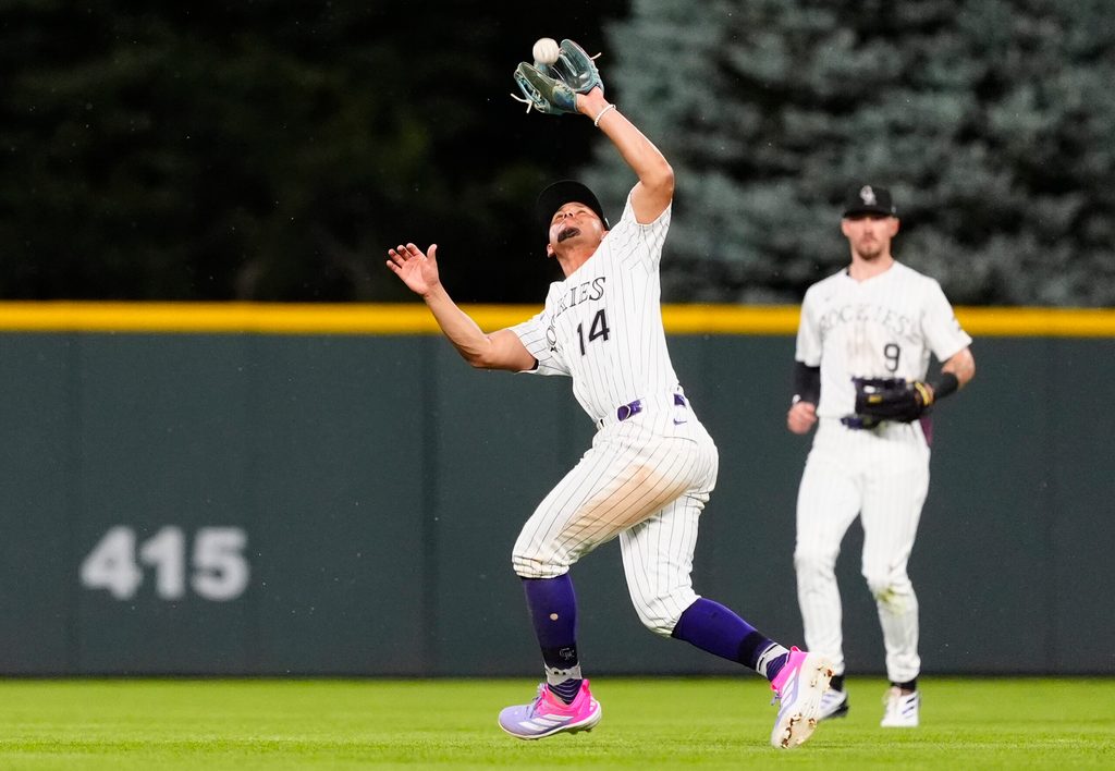 Jul 22, 2025; Denver, Colorado, USA; Colorado Rockies shortstop Ezequiel Tovar (14) fields the ball in the fifth inning against the St. Louis Cardinals at Coors Field. Mandatory Credit: Ron Chenoy-Imagn Images