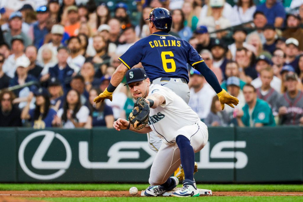 Jul 22, 2025; Seattle, Washington, USA; Seattle Mariners first baseman Luke Raley (20) drops a throw allowing Milwaukee Brewers right fielder Isaac Collins (6) safe during the seventh inning at T-Mobile Park. Mandatory Credit: Joe Nicholson-Imagn Images