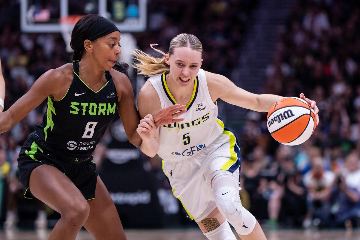 Jul 22, 2025; Seattle, Washington, USA; Dallas Wings guard Paige Bueckers (5) dribbles the ball against Seattle Storm guard Lexie Brown (8) during the second half at Climate Pledge Arena. Mandatory Credit: Stephen Brashear-Imagn Images