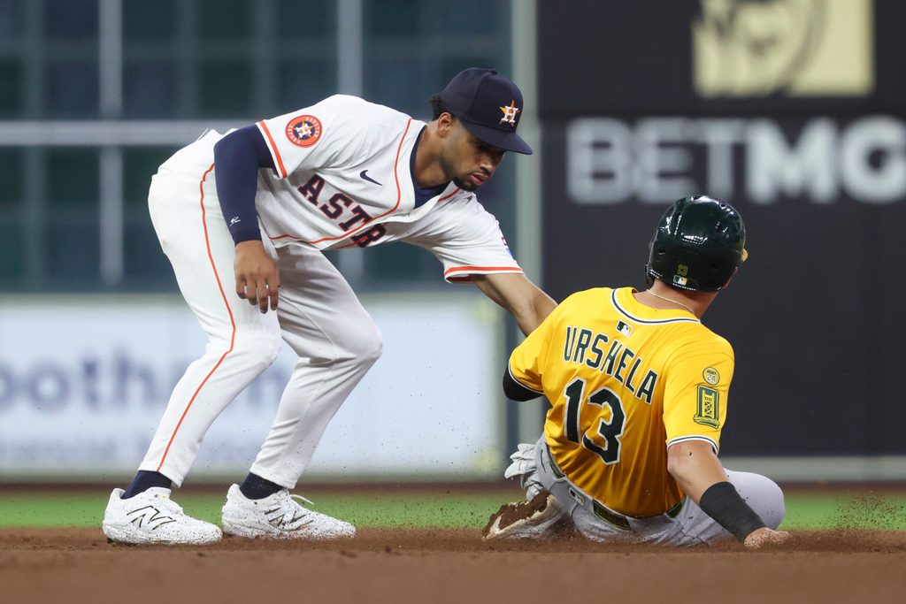 Jul 24, 2025; Houston, Texas, USA;  Athletics third baseman Gio Urshela (13) is out on a stolen base attempt as Houston Astros second baseman Brice Matthews (28) applies a tag during the eighth inning at Daikin Park. Mandatory Credit: Troy Taormina-Imagn Images