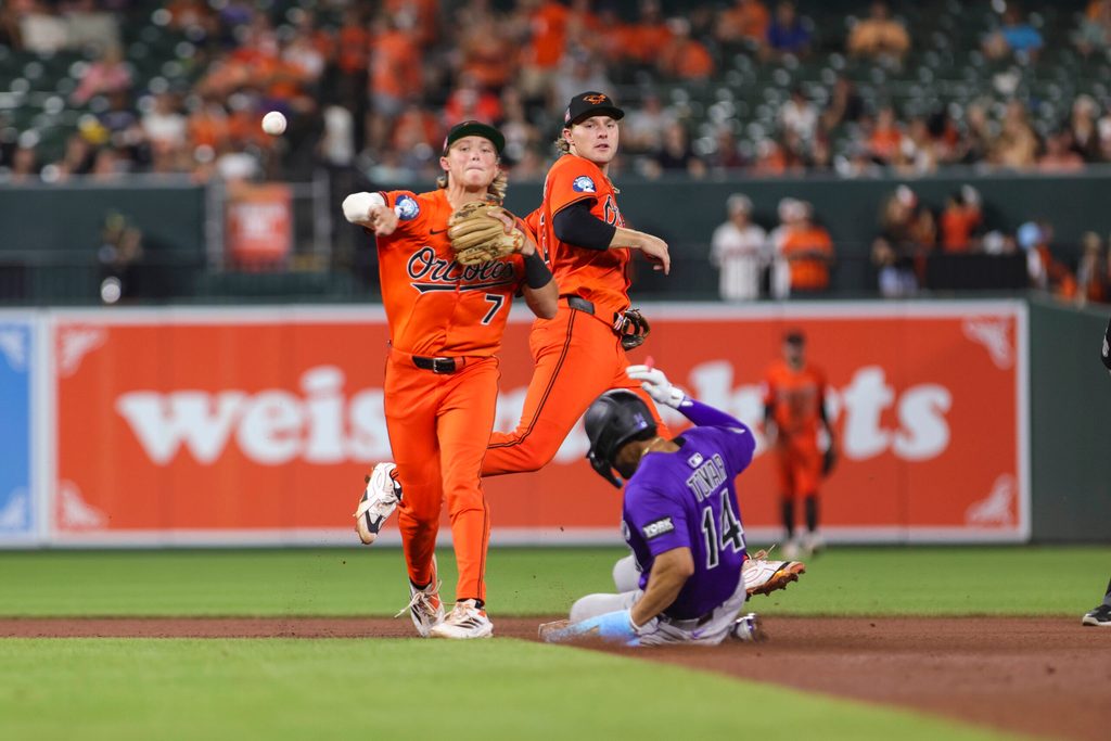 Jul 26, 2025; Baltimore, Maryland, USA; Baltimore Orioles’ second Baseman Jackson Holliday (7) turns a double play against the Colorado Rockies in the seventh inning  at Oriole Park at Camden Yards. Mandatory Credit: Lexi Thompson-Imagn Images