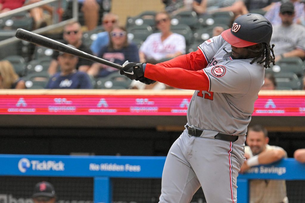Jul 27, 2025; Minneapolis, Minnesota, USA;  Washington Nationals designated hitter Josh Bell (19) hits a single against the Minnesota Twins during the seventh inning at Target Field. Mandatory Credit: Nick Wosika-Imagn Images