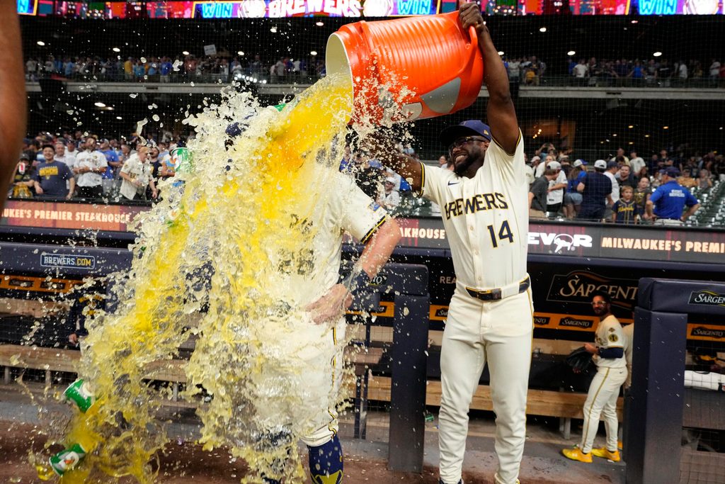 Jul 29, 2025; Milwaukee, Wisconsin, USA; Milwaukee Brewers shortstop Andruw Monasterio (14) dumps Gatorade over Milwaukee Brewers first base Andrew Vaughn (28) head after the game in which Milwaukee  Andrew Vaughn (28) hit a grand slam against the Chicago Cubs at American Family Field. Mandatory Credit: Michael McLoone-Imagn Images