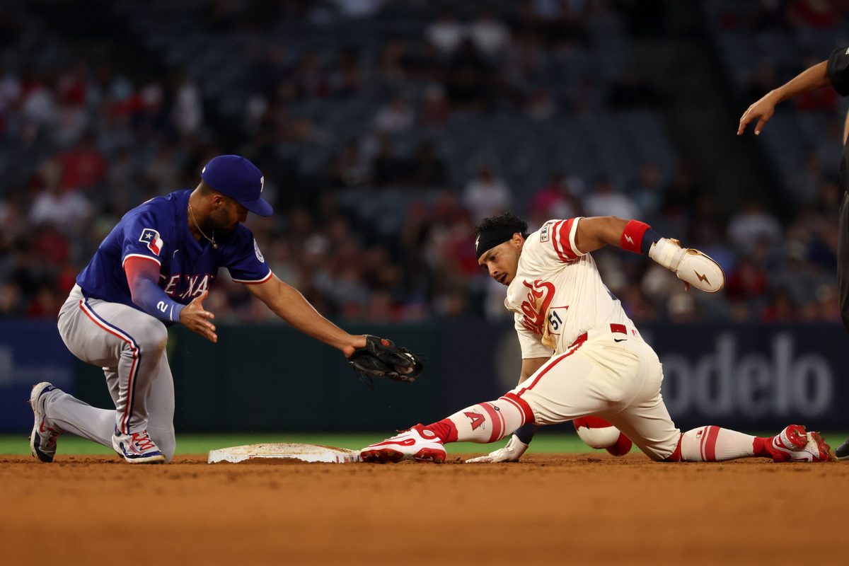 Jul 29, 2025; Anaheim, California, USA; Los Angeles Angels right fielder Gustavo Campero (51) is tagged out by Texas Rangers second baseman Marcus Semien (2) as he tries to steal second during the fourth inning at Angel Stadium. Mandatory Credit: Kiyoshi Mio-Imagn Images