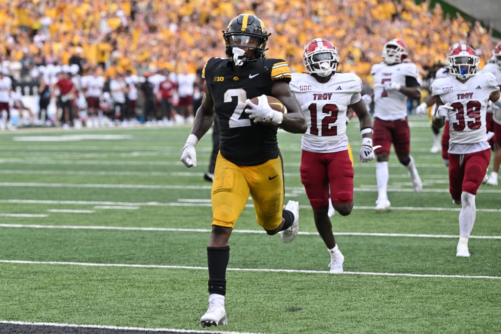 Sep 14, 2024; Iowa City, Iowa, USA; Iowa Hawkeyes running back Kaleb Johnson (2) scores on a 33 yard run as Troy Trojans cornerback Trent Henry (12) and safety Ian Conerly-Goodly (39) pursue during the fourth quarter at Kinnick Stadium. Mandatory Credit: Jeffrey Becker-Imagn Images