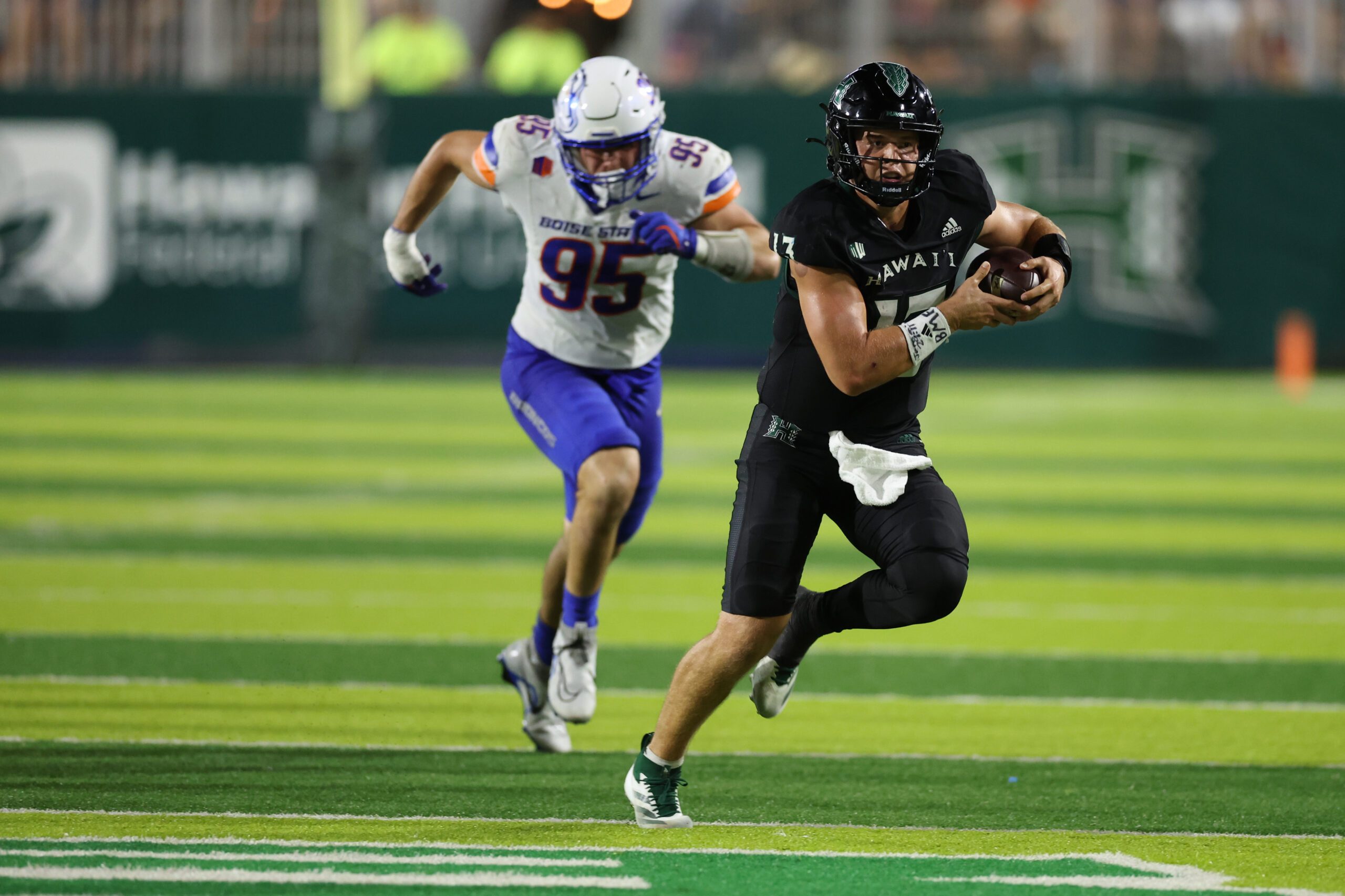 Oct 12, 2024; Honolulu, Hawaii, USA;  Hawaii Rainbow Warriors quarterback Brayden Schager (13) gets chased down by Boise State Broncos defensive end Max Stege (95) during the fourth quarter of a NCAA college football game at Clarence T.C. Ching Athletics Complex. Mandatory Credit: Marco Garcia-Imagn Images
