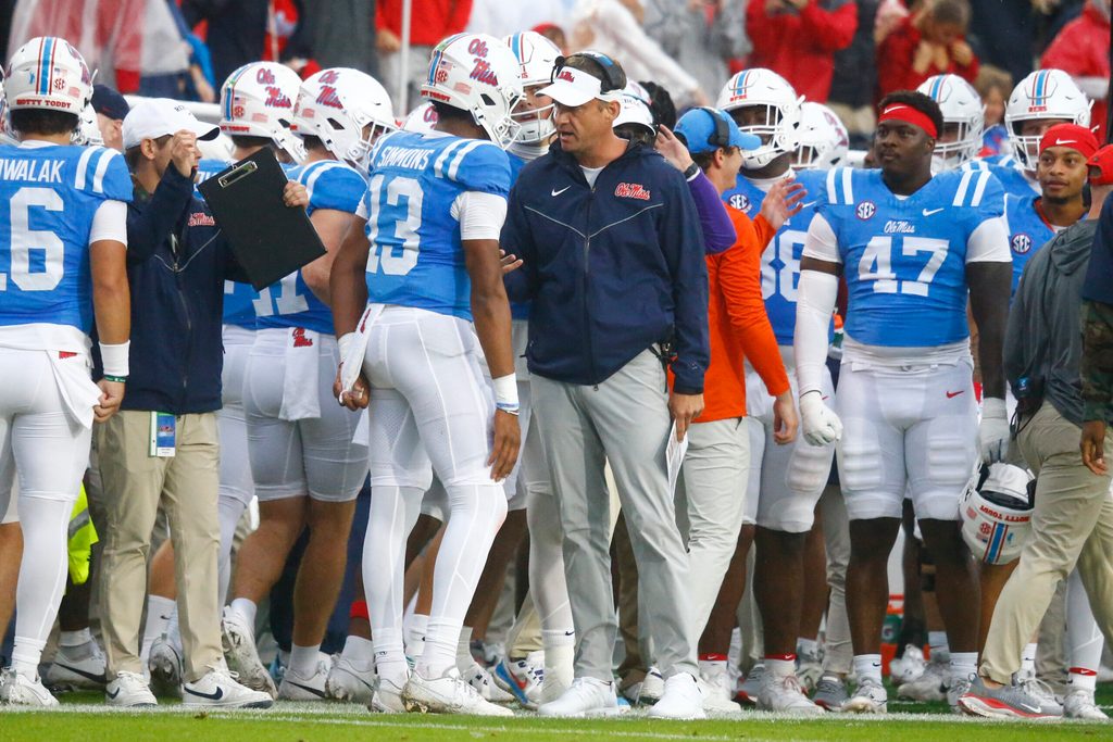 Nov 9, 2024; Oxford, Mississippi, USA; Mississippi Rebels head coach Lane Kiffin talks with quarterback Austin Simmons (13) after a touchdown during the first half against the Georgia Bulldogs at Vaught-Hemingway Stadium. Mandatory Credit: Petre Thomas-Imagn Images