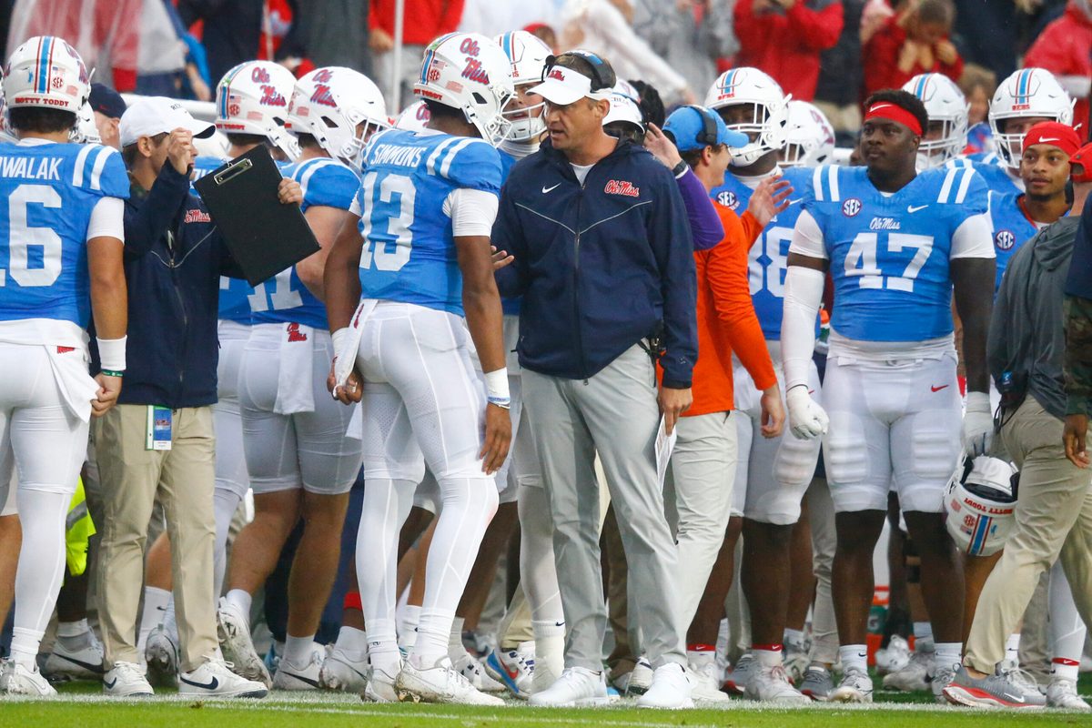 Nov 9, 2024; Oxford, Mississippi, USA; Mississippi Rebels head coach Lane Kiffin talks with quarterback Austin Simmons (13) after a touchdown during the first half against the Georgia Bulldogs at Vaught-Hemingway Stadium. Mandatory Credit: Petre Thomas-Imagn Images