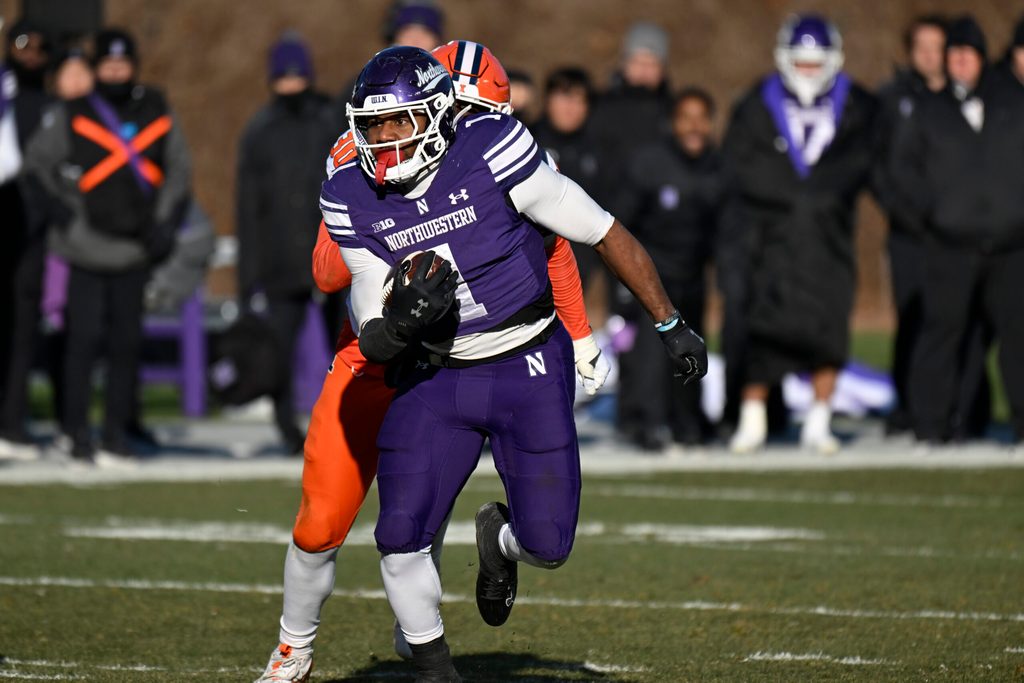 Nov 30, 2024; Chicago, Illinois, USA;  Northwestern Wildcats running back Cam Porter (1) runs the ball against the Illinois Fighting Illini during the second half at Wrigley Field. Mandatory Credit: Matt Marton-Imagn Images