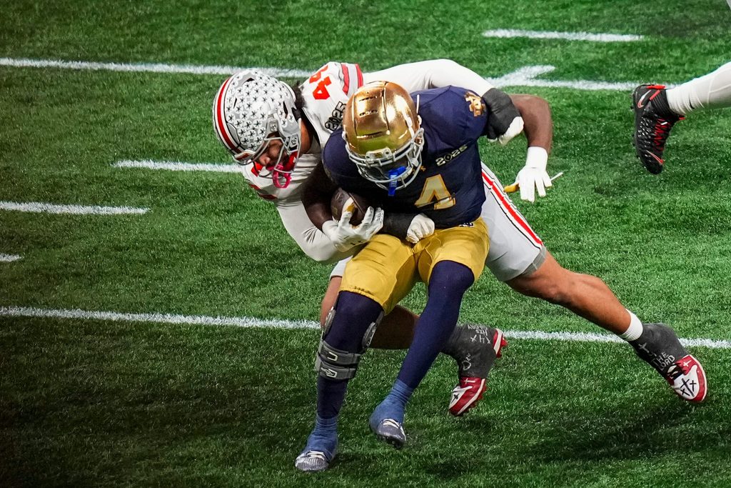 Ohio State Buckeyes defensive end JT Tuimoloau (44) tackles Notre Dame Fighting Irish running back Jeremiyah Love (4) during the College Football Playoff championship at Mercedes-Benz Stadium in Atlanta on Jan. 20, 2025.