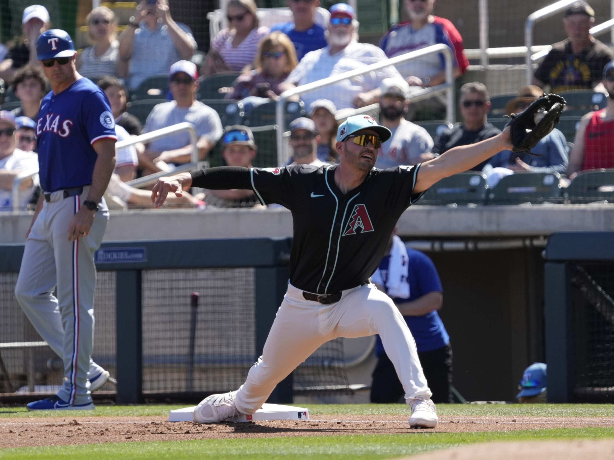Arizona Diamondbacks first baseman Trey Mancini stretches for a throw against the Texas Rangers during Cactus League play at Salt River Fields on March 9, 2025.