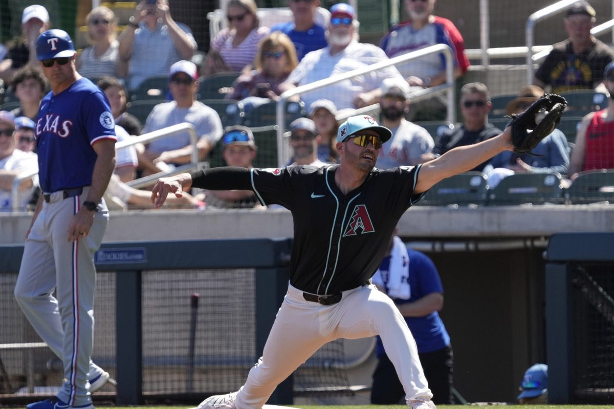 Arizona Diamondbacks first baseman Trey Mancini stretches for a throw against the Texas Rangers during Cactus League play at Salt River Fields on March 9, 2025.