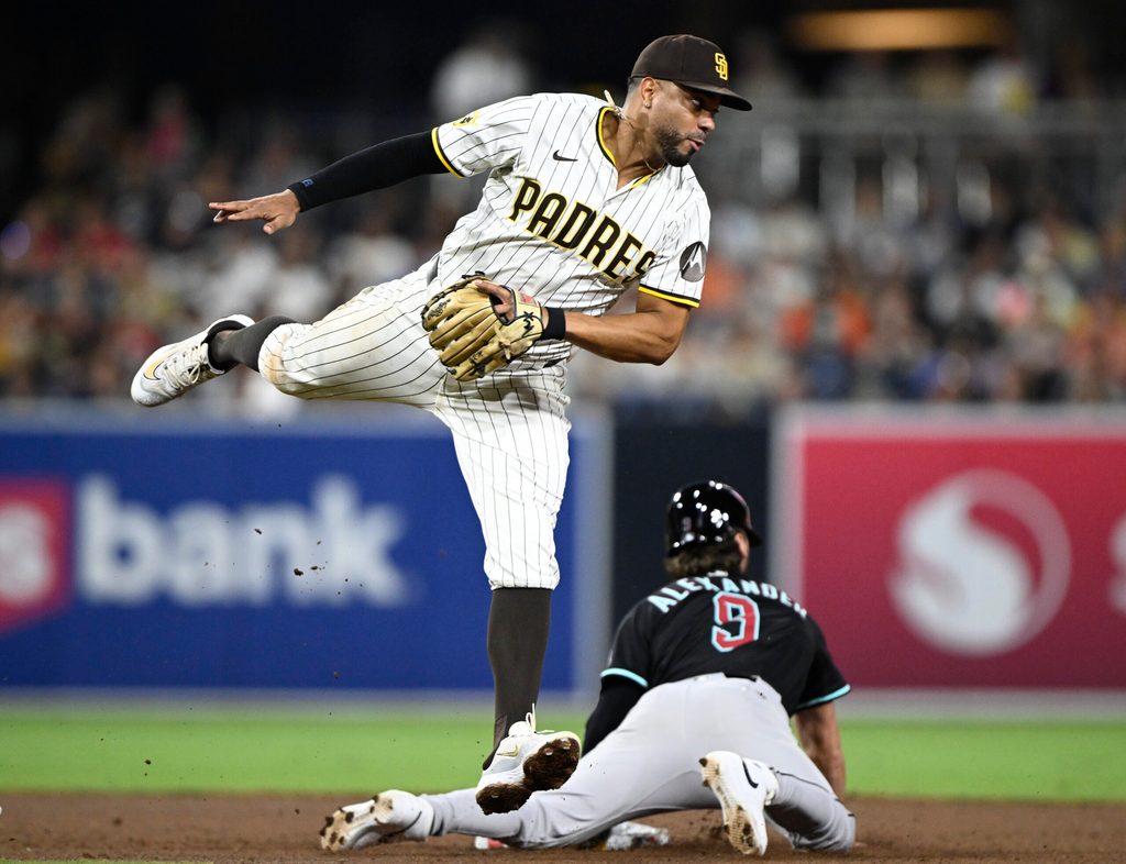 Jul 10, 2025; San Diego, California, USA; San Diego Padres shortstop Xander Bogaerts (2) jumps for a high throw as Arizona Diamondbacks shortstop Blaze Alexander (9) steals second base during the eighth inning at Petco Park. Mandatory Credit: Denis Poroy-Imagn Images