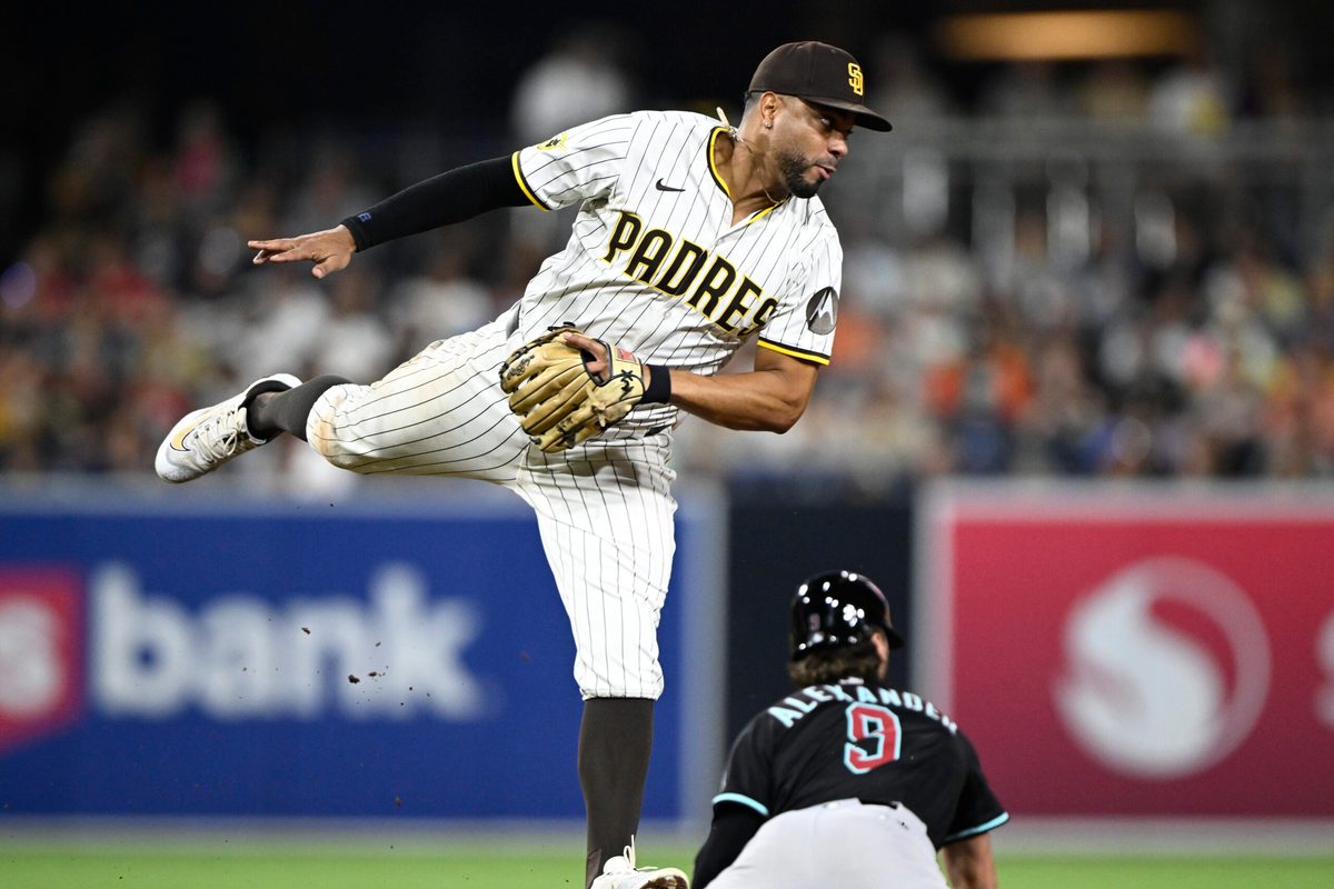 Jul 10, 2025; San Diego, California, USA; San Diego Padres shortstop Xander Bogaerts (2) jumps for a high throw as Arizona Diamondbacks shortstop Blaze Alexander (9) steals second base during the eighth inning at Petco Park. Mandatory Credit: Denis Poroy-Imagn Images