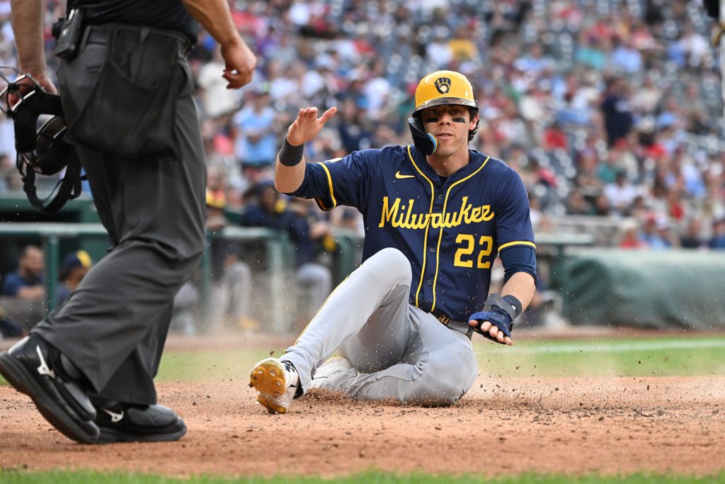 Aug 2, 2025; Washington, District of Columbia, USA; Milwaukee Brewers left fielder Christian Yelich (22) slides into home plate to score a run against the Washington Nationals during the ninth inning at Nationals Park. Mandatory Credit: Rafael Suanes-Imagn Images