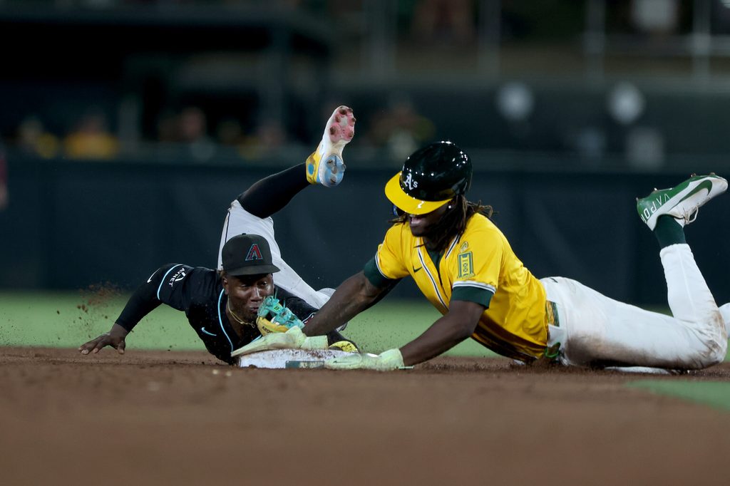 Aug 2, 2025; West Sacramento, California, USA; Arizona Diamondbacks shortstop Geraldo Perdomo (2) dives towards second base ahead of Athletics center fielder Lawrence Butler (4) for a force out during the fifth inning at Sutter Health Park. Mandatory Credit: Dennis Lee-Imagn Images