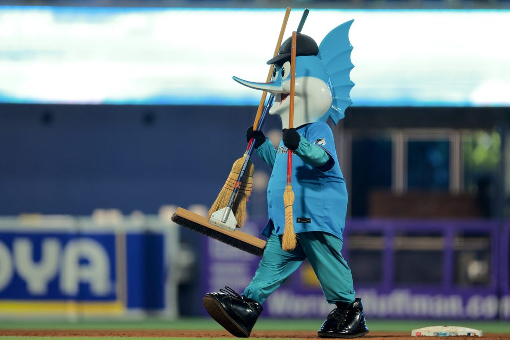 Aug 3, 2025; Miami, Florida, USA; Miami Marlins mascot Billy the Marlins walks with three brooms after the Miami Marlins swept the New York Yankees at loanDepot Park. Mandatory Credit: Sam Navarro-Imagn Images