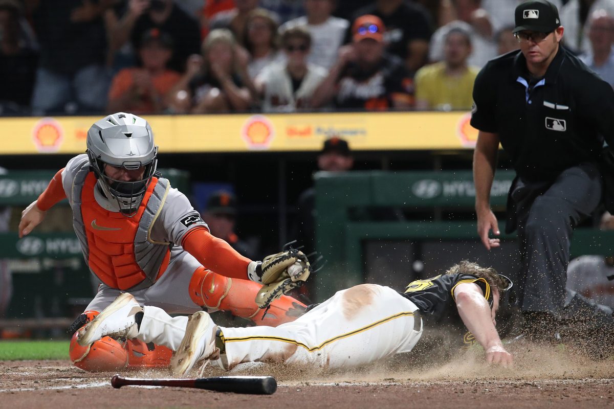 Aug 4, 2025; Pittsburgh, Pennsylvania, USA;  Pittsburgh Pirates right fielder Jack Suwinski (right) slides past San Francisco Giants catcher Patrick Bailey (14) to score the game winning run during the ninth inning at PNC Park. Mandatory Credit: Charles LeClaire-Imagn Images
