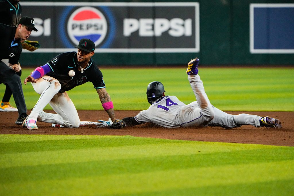 Aug 9, 2025; Phoenix, Arizona, USA; Colorado Rockies shortstop Ezequiel Tovar (14) slides into second base while Arizona Diamondbacks shortstop Geraldo Perdomo (2) misses the throw in the third inning of the game between the Arizona Diamondbacks and Colorado Rockies at Chase Field. Mandatory Credit: Arianna Grainey-Imagn Images