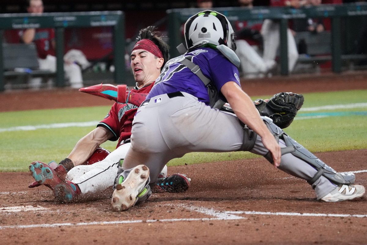 Arizona Diamondbacks baserunner Corbin Carroll (7) slides in to score a run past Colorado Rockies catcher Braxton Fulford (37) at Chase Field on Aug. 10, 2025.
