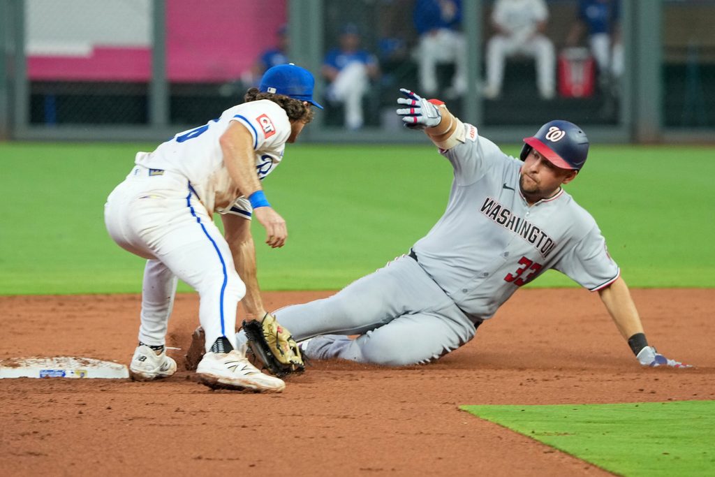 Aug 11, 2025; Kansas City, Missouri, USA; Kansas City Royals second baseman Adam Frazier (26) misses the tag as Washington Nationals first baseman Nathaniel Lowe (33) reaches second base on a double in the fifth inning at Kauffman Stadium. Mandatory Credit: Denny Medley-Imagn Images