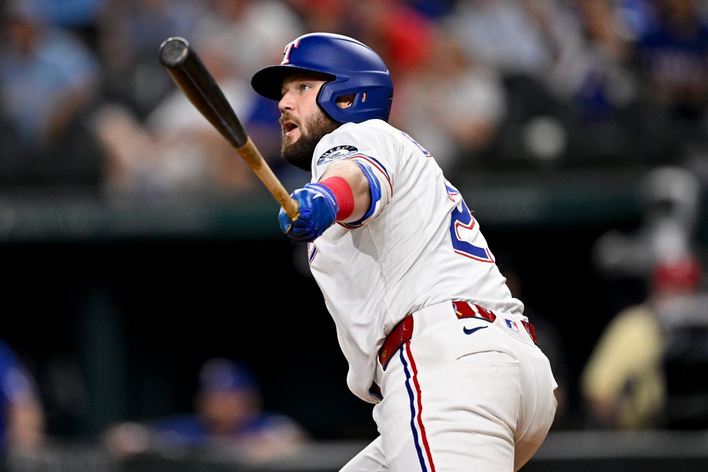 Aug 11, 2025; Arlington, Texas, USA; Texas Rangers pinch hitter Jake Burger (21) hits a single and drives in the game winning run against the Arizona Diamondbacks during the tenth inning at Globe Life Field. Mandatory Credit: Jerome Miron-Imagn Images
