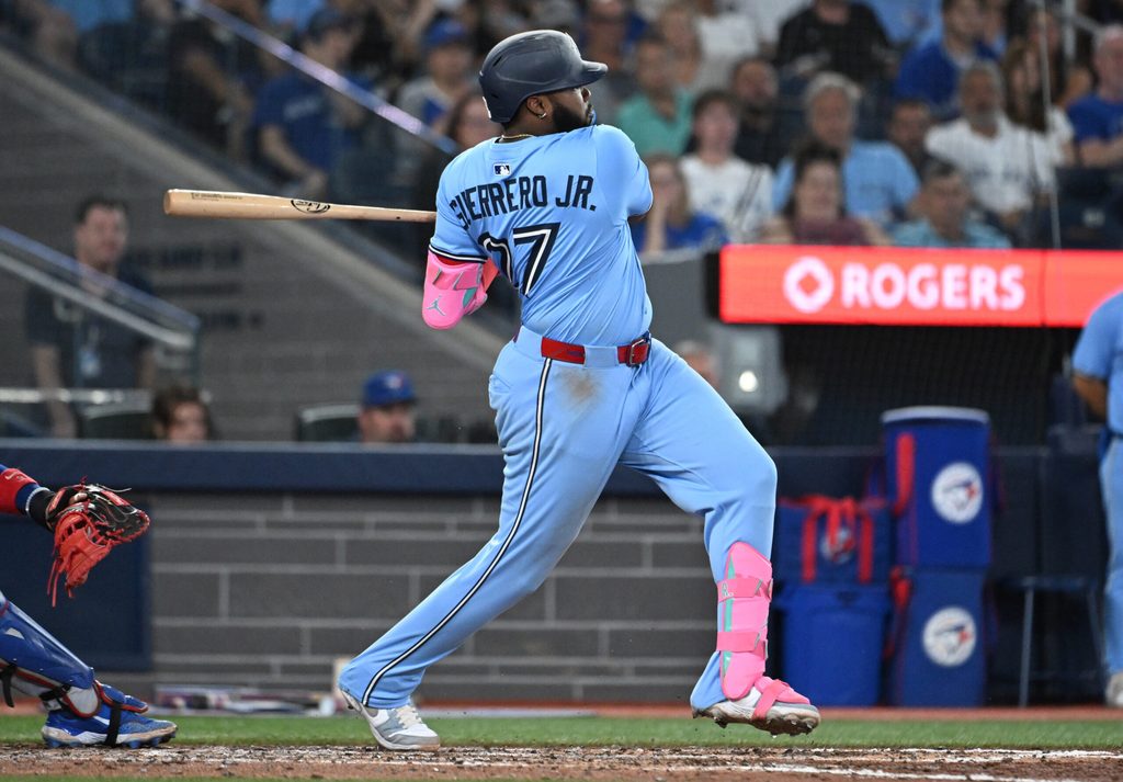 Aug 13, 2025; Toronto, Ontario, CAN; Toronto Blue Jays first baseman Vladimir Guerrero Jr. (27) hits an RBI double against the Chicago Cubs in the sixth inning at Rogers Centre. Mandatory Credit: Dan Hamilton-Imagn Images