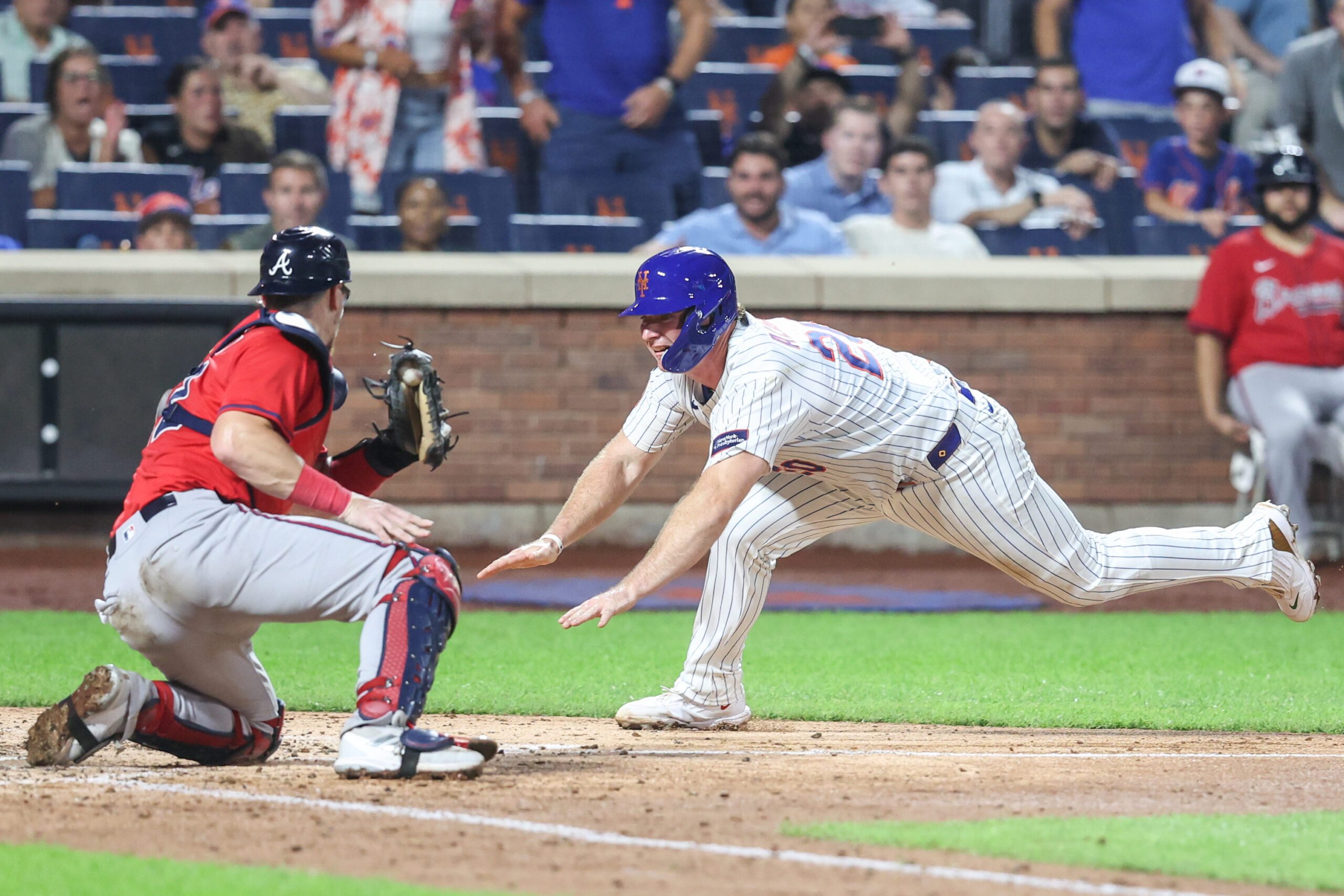 Aug 13, 2025; New York City, New York, USA; New York Mets first baseman Pete Alonso (20) attempts to beat the tag of Atlanta Braves catcher Sean Murphy (12) in the fourth inning at Citi Field. Mandatory Credit: Wendell Cruz-Imagn Images