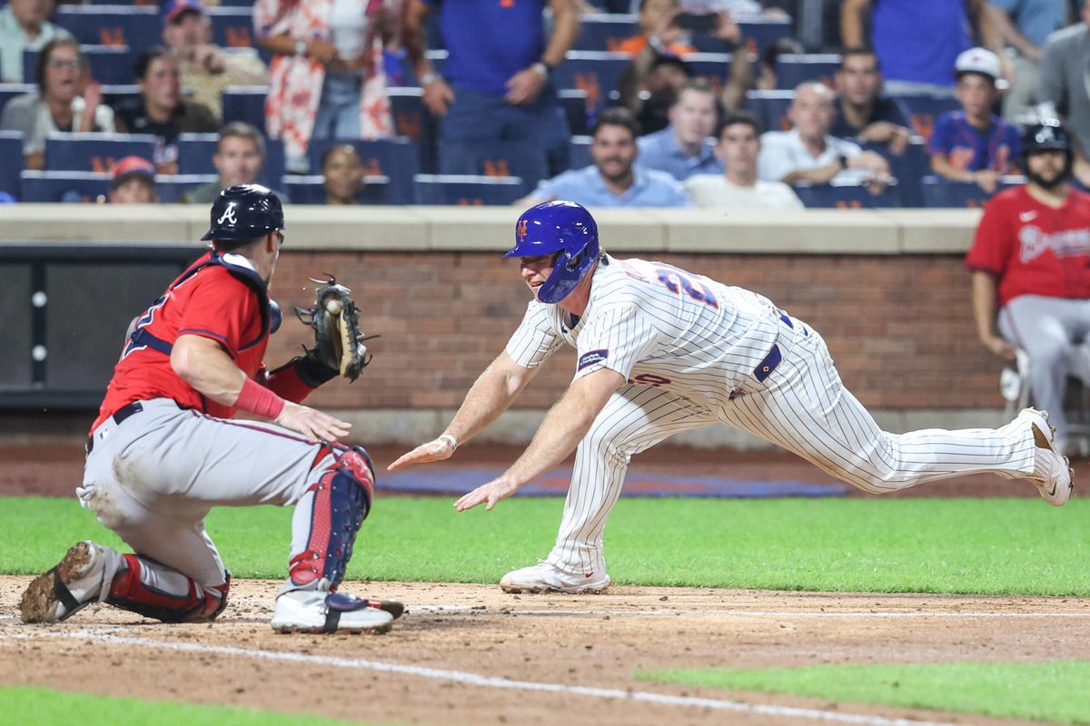 Aug 13, 2025; New York City, New York, USA;  New York Mets first baseman Pete Alonso (20) attempts to beat the tag of Atlanta Braves catcher Sean Murphy (12) in the fourth inning at Citi Field. Mandatory Credit: Wendell Cruz-Imagn Images