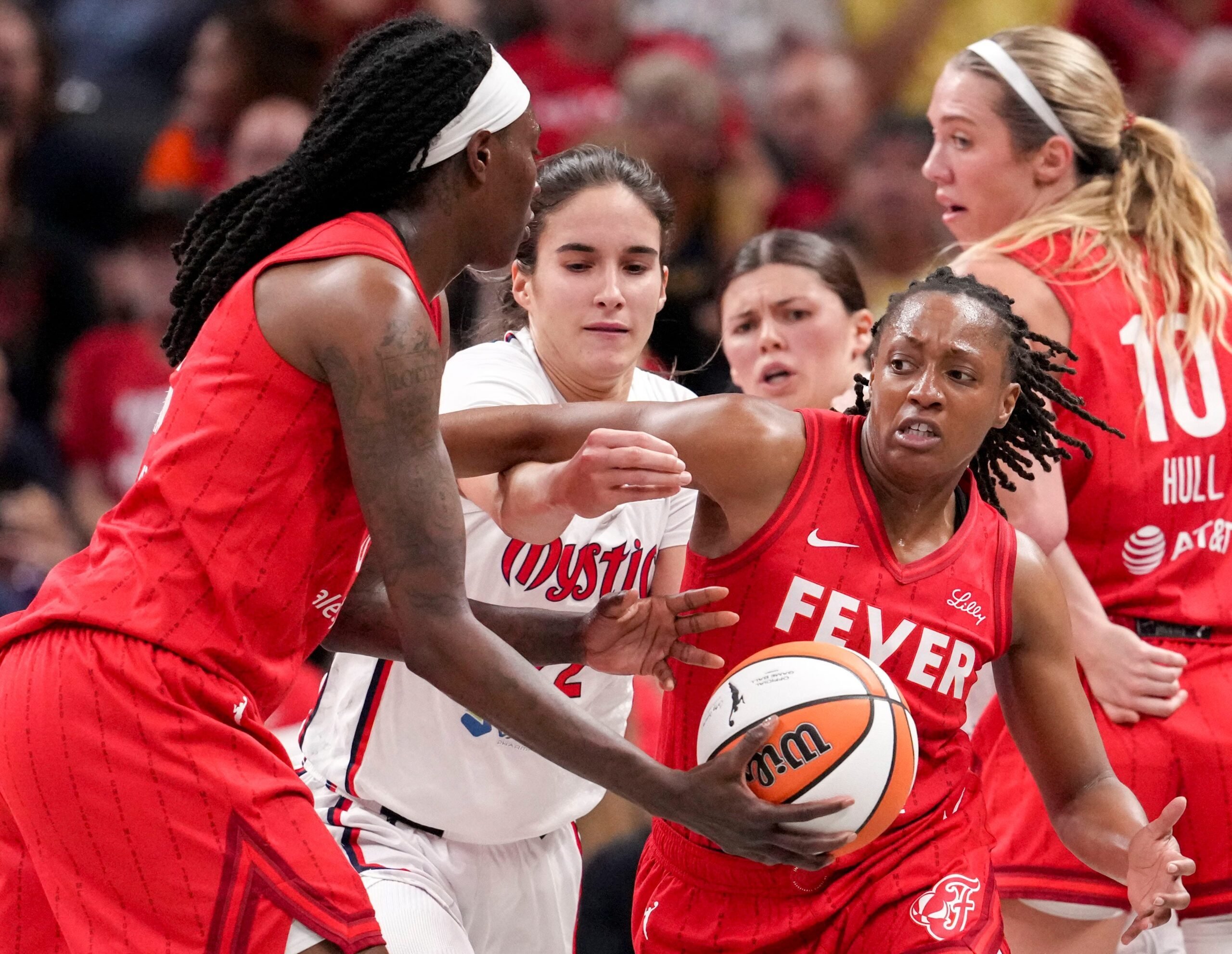 Indiana Fever forward Natasha Howard (6) hands off the ball to guard Kelsey Mitchell (0) during the first half of a game against the Washington Mystics on Friday, Aug. 15, 2025, at Gainbridge Fieldhouse in Indianapolis.