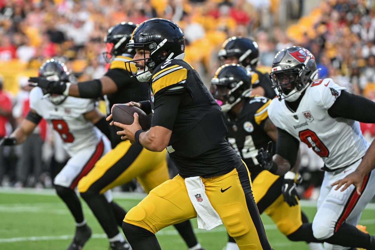 Aug 16, 2025; Pittsburgh, Pennsylvania, USA; Pittsburgh Steelers quarterback Mason Rudolph (2) scrambles away from Tampa Bay Buccaneers linebacker Yaya Diaby (0) during the first quarter at Acrisure Stadium. Mandatory Credit: Barry Reeger-Imagn Images