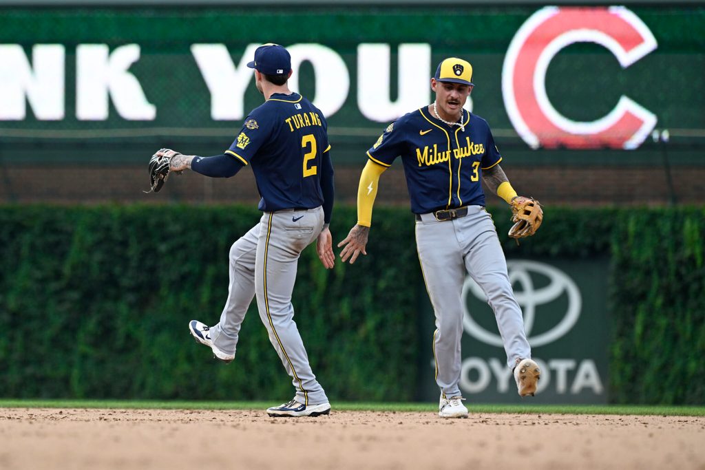 Aug 18, 2025; Chicago, Illinois, USA;  Milwaukee Brewers second baseman Brice Turang (2) and  shortstop Joey Ortiz (3) celebrate after the game against the Chicago Cubs at Wrigley Field. Mandatory Credit: Matt Marton-Imagn Images