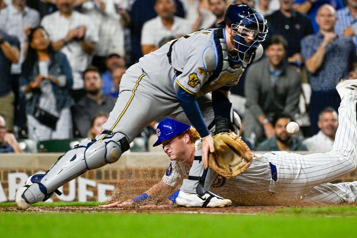 Aug 19, 2025; Chicago, Illinois, USA; Chicago Cubs outfielder Owen Caissie (19) scores past Milwaukee Brewers catcher Danny Jansen (33) during the second inning at Wrigley Field. Mandatory Credit: Matt Marton-Imagn Images