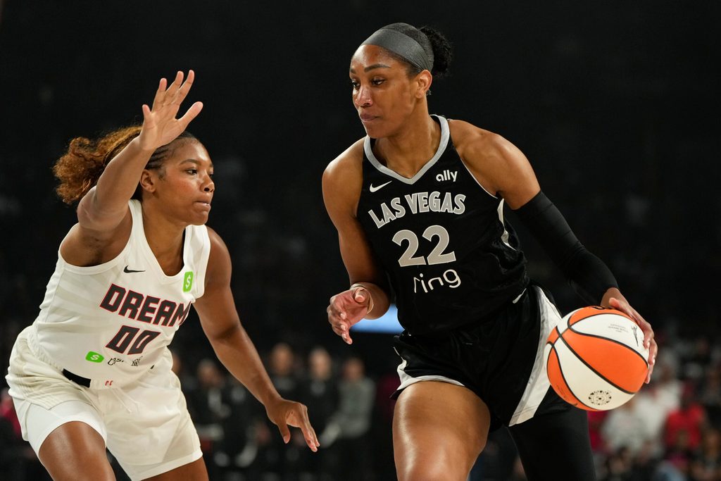 Aug 19, 2025; Las Vegas, Nevada, USA; Las Vegas Aces center A'ja Wilson (22) drives the ball past Atlanta Dream forward Naz Hillmon (00) during the first half of a WNBA basketball game at Michelob Ultra Arena. Mandatory Credit: Lucas Peltier-Imagn Images