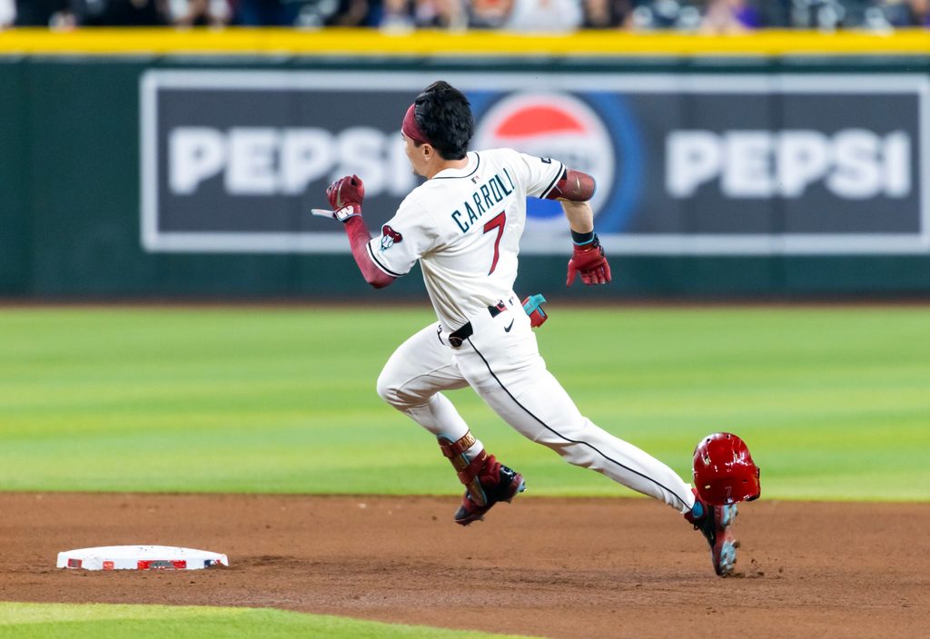 Aug 19, 2025; Phoenix, Arizona, USA; Arizona Diamondbacks outfielder Corbin Carroll loses his helmet as he runs the bases after hitting a triple in the fourth inning against the Cleveland Guardians at Chase Field. Mandatory Credit: Mark J. Rebilas-Imagn Images