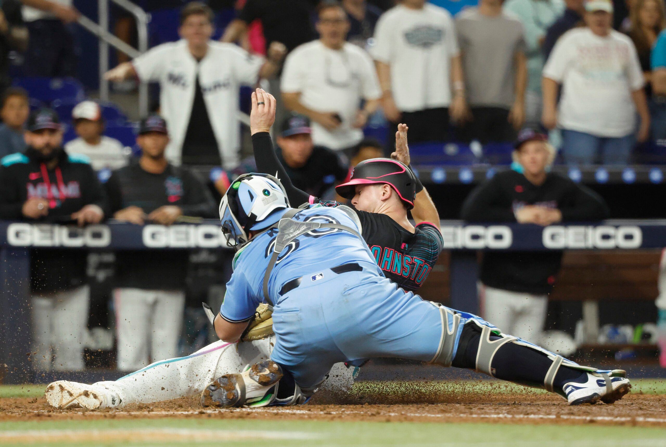 Aug 23, 2025; Miami, Florida, USA; Toronto Blue Jays catcher Alejandro Kirk (30) tags out Miami Marlins outfielder Troy Johnston (75) at the plate during the seventh inning at loanDepot Park. Mandatory Credit: Rhona Wise-Imagn Images