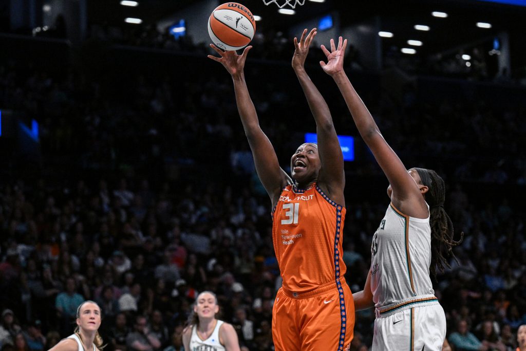Aug 25, 2025; Brooklyn, New York, USA; Connecticut Sun center Tina Charles (31) shoots the ball while defended by New York Liberty center Jonquel Jones (35) during the second half at Barclays Center. Mandatory Credit: John Jones-Imagn Images