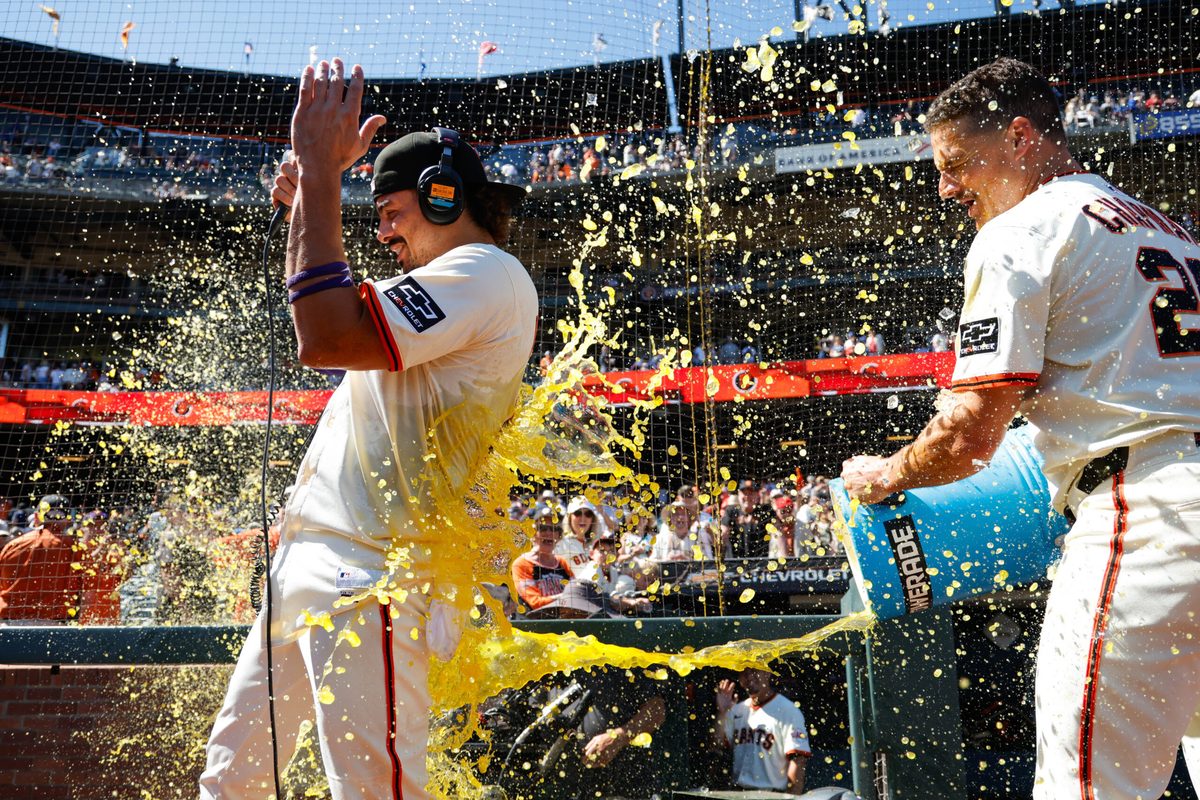 Aug 28, 2025; San Francisco, California, USA; San Francisco Giants shortstop Willy Adames (2) gets a gatorade splash by third baseman Matt Chapman (26) after the game against the Chicago Cubs at Oracle Park. Mandatory Credit: Sergio Estrada-Imagn Images