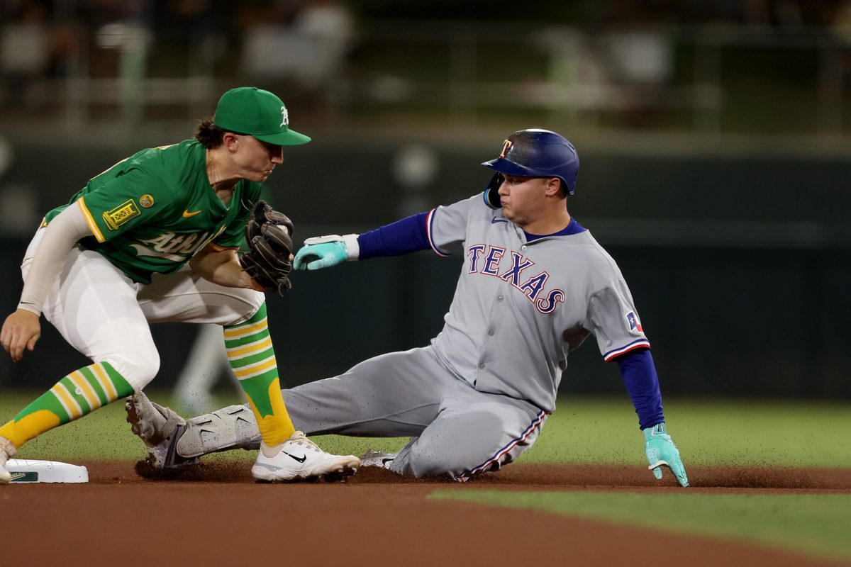 Aug 30, 2025; West Sacramento, California, USA; Texas Rangers designated hitter Joc Pederson (4) slides ahead of Athletics second baseman Zack Gelof’s tag (left) during the seventh inning at Sutter Health Park. Mandatory Credit: Dennis Lee-Imagn Images