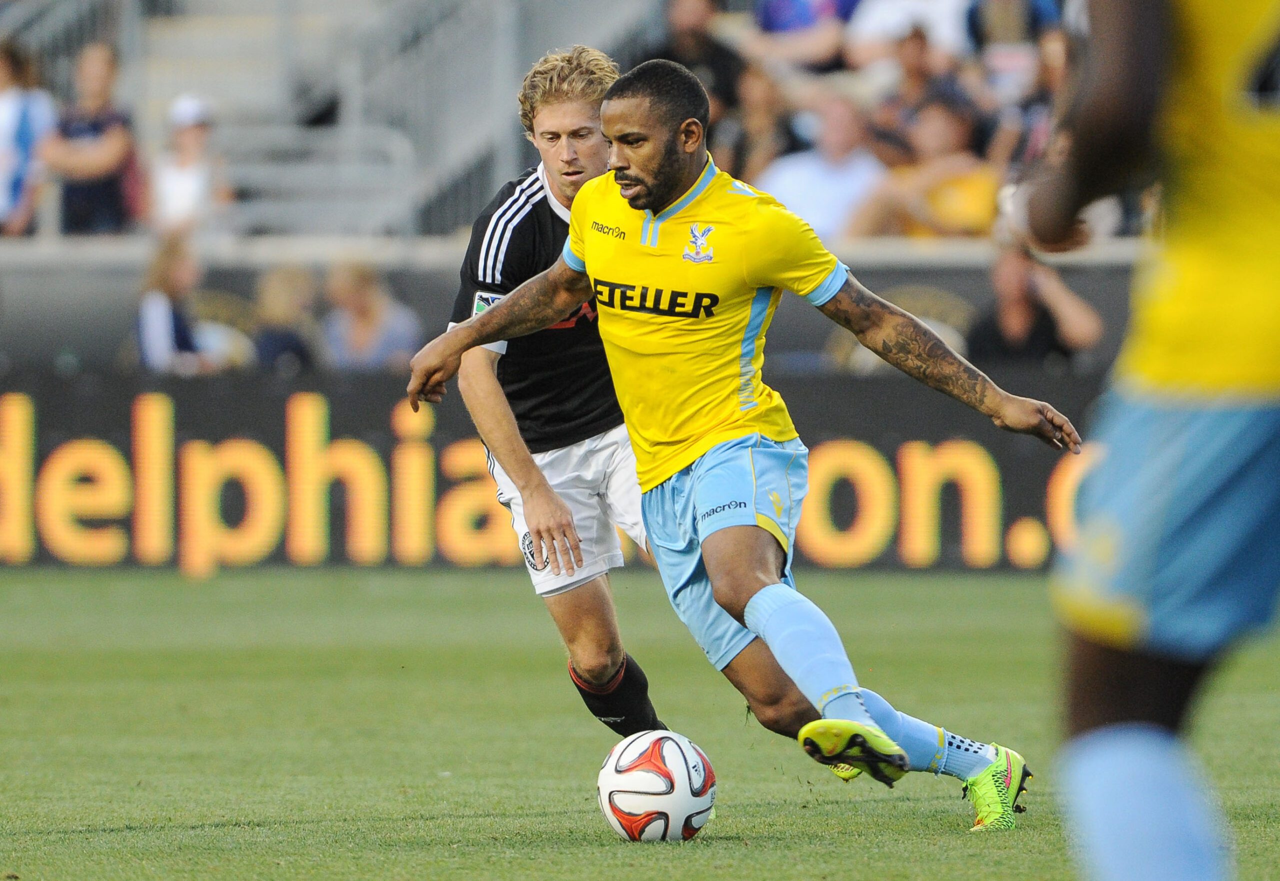 Jul 25, 2014; Chester, PA, USA; Crystal Palace midfielder Jason Puncheon (13) moves the ball as Crystal Palace midfielder Yannick Bolasie (7) defends during the second half of the match at PPL Park. Crystal Palace FC won the match 1-0. Mandatory Credit: John Geliebter-Imagn Images