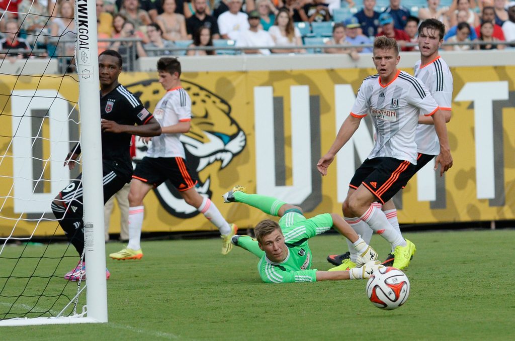 Jul 26, 2014; Jacksonville, FL, USA; Fulham FC goalie Jesse Joronen (41) makes a diving save against D.C. United forward Michael Seaton (29) at EverBank Field. Mandatory Credit: Richard Dole-Imagn Images