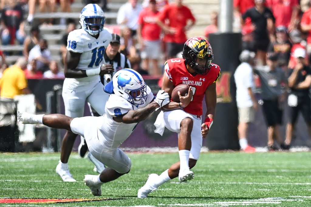 Sep 3, 2022; College Park, Maryland, USA; Buffalo Bulls wide receiver Jovany Ruiz-Navarro (8) tackles Maryland Terrapins quarterback Taulia Tagovailoa (3) during the first half at Capital One Field at Maryland Stadium. Mandatory Credit: Tommy Gilligan-Imagn Images