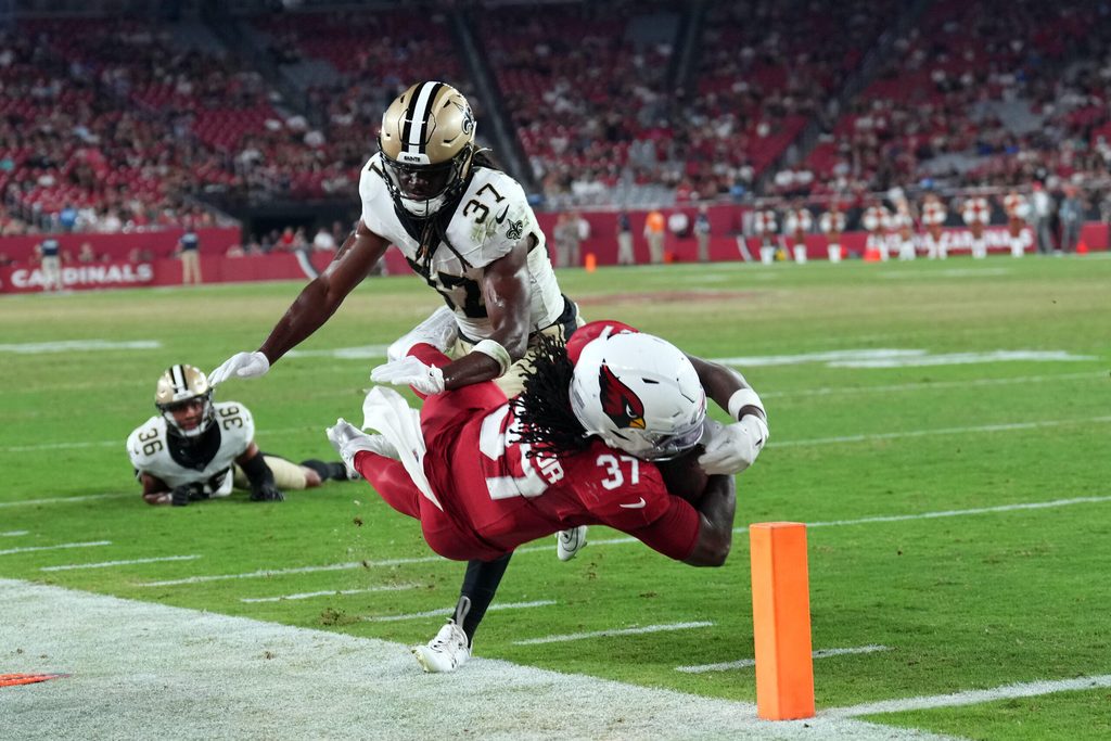 Aug 10, 2024; Glendale, Arizona, USA; Arizona Cardinals running back Tony Jones Jr. (37) dives past New Orleans Saints safety Lawrence Johnson (37) for a touchdown during the second half at State Farm Stadium. Mandatory Credit: Joe Camporeale-Imagn Images