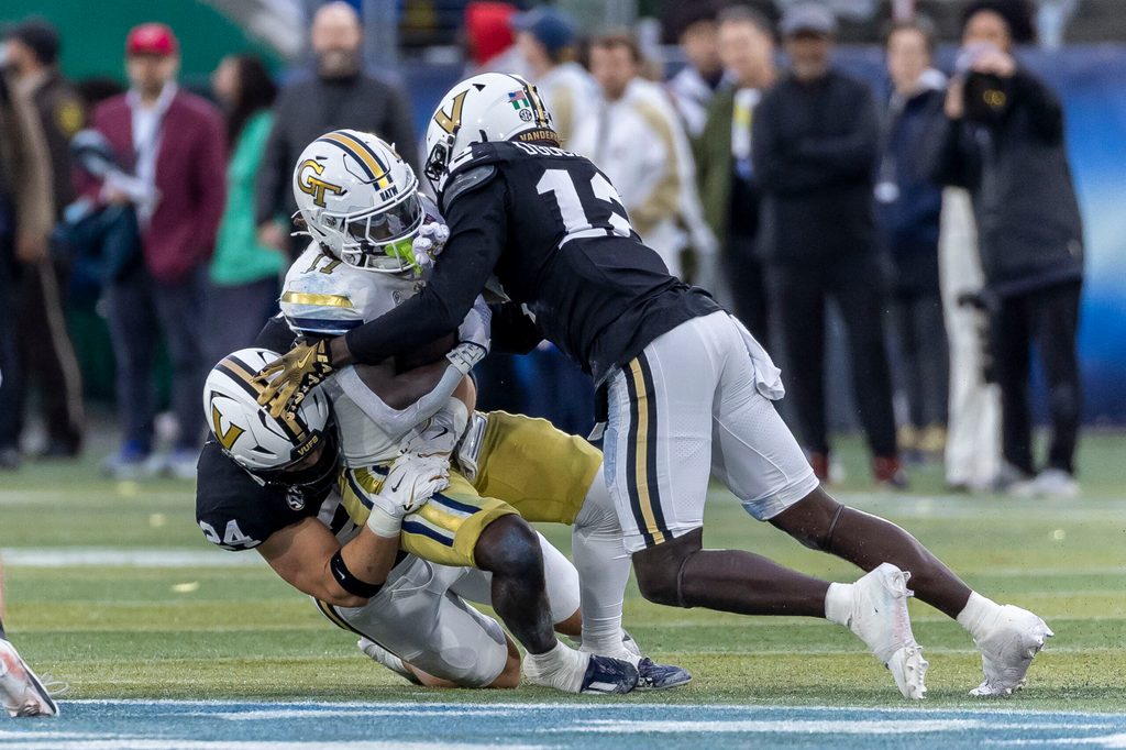 Dec 27, 2024; Birmingham, AL, USA; Vanderbilt Commodores linebackers Nick Rinaldi (24) and Jeffrey Ugochukwu (12) stop Georgia Tech Yellow Jackets running back Jamal Haynes (11) during the first half of the 2024 Birmingham Bowl at Protective Stadium. Mandatory Credit: Vasha Hunt-Imagn Images