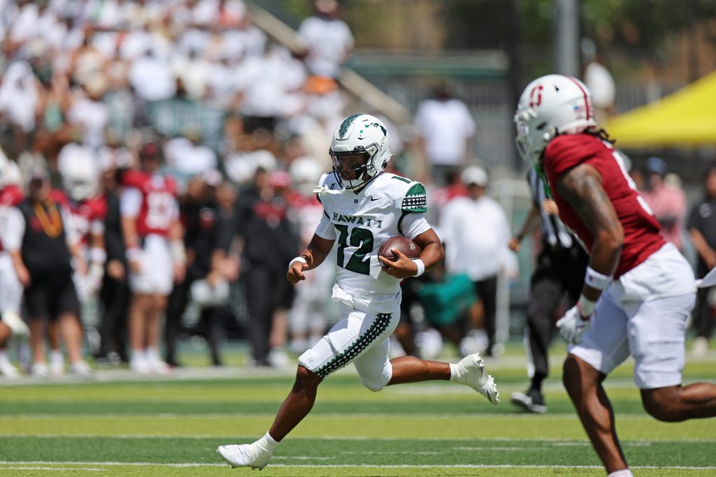 Aug 23, 2025; Honolulu, Hawaii, USA; Hawaii Rainbow Warriors quarterback Micah Alejado (12) runs through the Stanford Cardinal defense during the first half of an NCAA college football game at Clarence T.C. Ching Athletics Complex. Mandatory Credit: Marco Garcia-Imagn Images