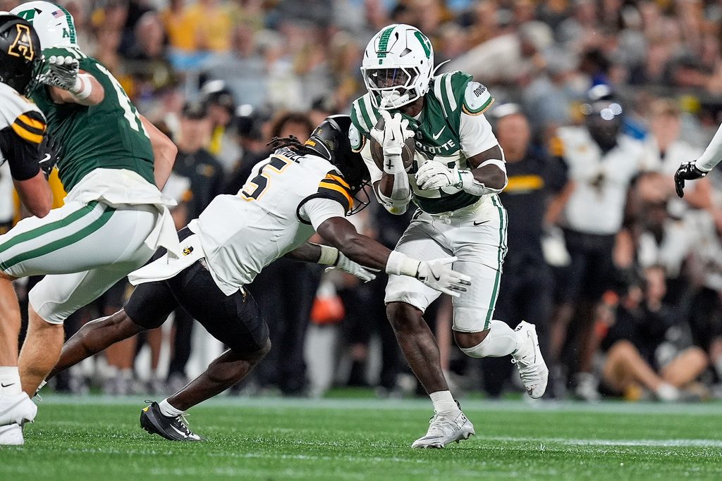 Aug 29, 2025; Charlotte, North Carolina, USA; Charlotte 49ers running back CJ Stokes (23) is tackled by Appalachian State Mountaineers defensive back Zyeir Gamble (5) during the second half at Bank of America Stadium. Mandatory Credit: Jim Dedmon-Imagn Images